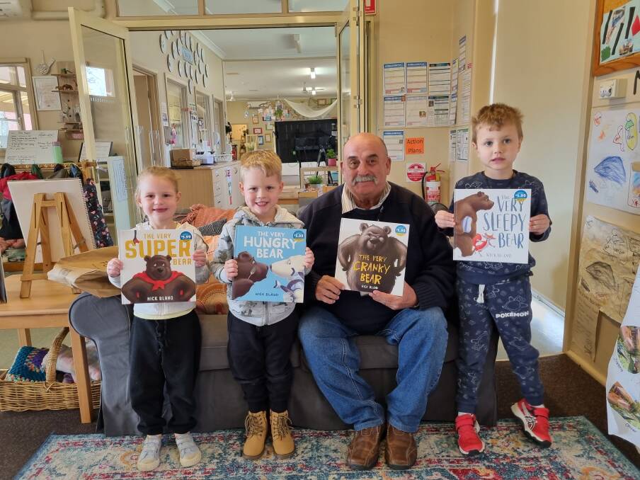 Goulburn Mulwaree Mayor Peter Walker and friends show off the new aditions to SDN Lady McKell's library. The books were donated by the Walker family. Picture supplied.