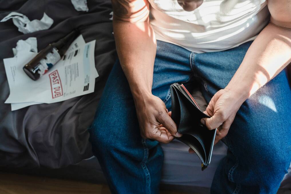 Man holding empty wallet. Picture by Nicola Barts (Pexels)