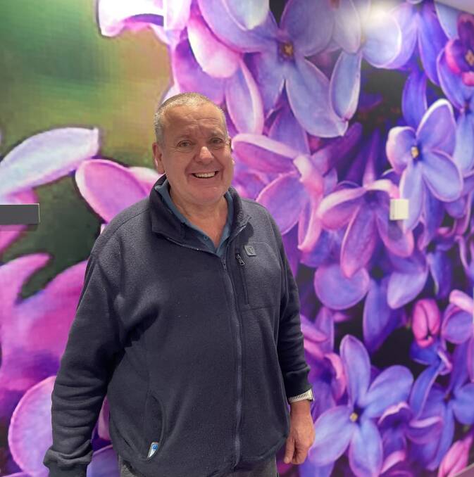 Angus Robards in front of his lilac photograph. Picture supplied