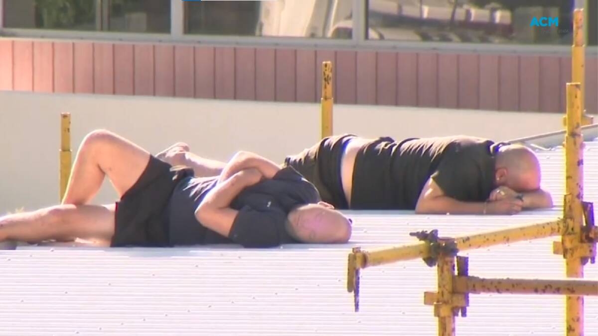 The two Beechboro men nap on the construction site roof during the standoff with police. Picture via Nine News