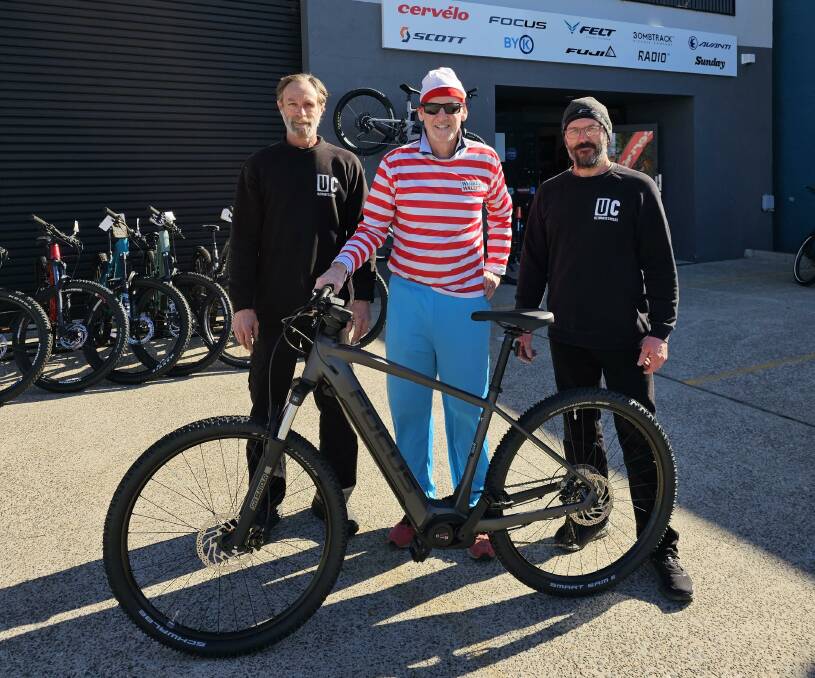 Dr Michael Davey takes delivery of his pedal-assisted Focus e-bike from Russell and Stewart at Ultimate Cycles ahead his latest fundraising ride around Australia. Picture supplied.