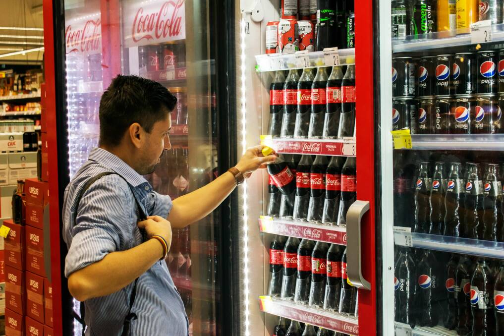 Image of a man reaching for a Coca-Cola. Picture from Shutterstock