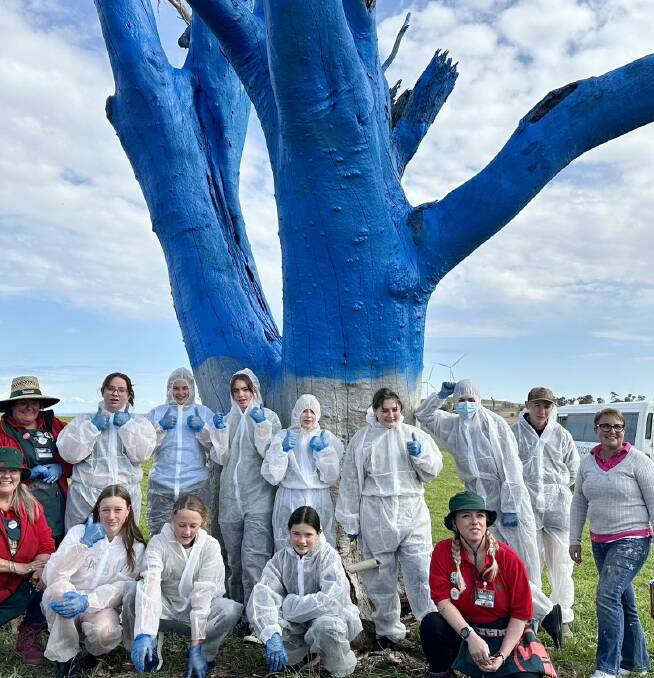 Students from Crookwell Highschool assist with painting a tree bright blue to start a conversation about mental health. Image supplied. 