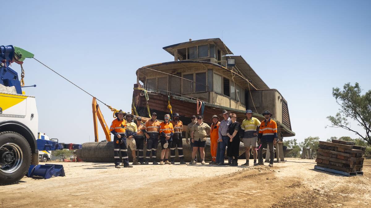 The salvage crew in front of the Pride of the Murray resting on hardstand beside the Thomson River. Picture supplied.