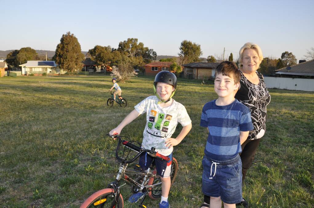 Vicki Valentine says her three grandsons, Lachlan (on bike at rear), Nicholas and Perry love playing in the park across the road from their home. Ms Valentine is among those opposed to its land exchange for social housing on the park. Picture by Louise Thrower.