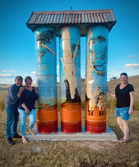 Artist Amy Curran with her mini-silo art completed for Neil and Karyn Bennett on their Taralga property. It can be seen from the roadway on Hillas Street. Picture supplied. 