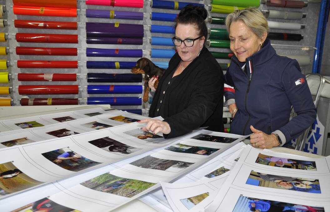 Studio 4 Signs and Design owner, Liz Townsend, and photographer, Tina Milson, discuss the finishing touches for the Portraits on Main exhibition. Picture by Louise Thrower.