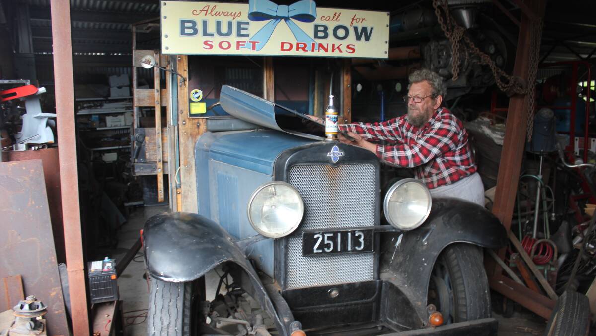 TINKERING: John Walker making some repairs to his beloved Blue Bow Chevrolet truck.