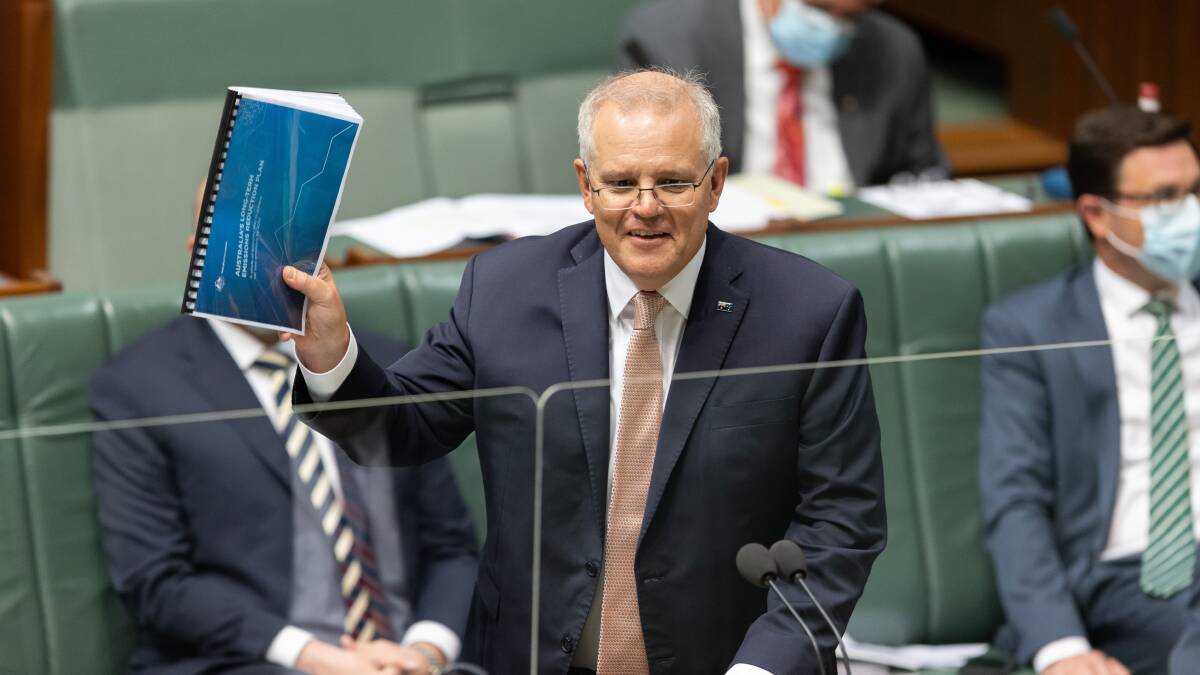 Scott Morrison brandishes a copy of the government's emissions plan during question time. Picture: Sitthixay Ditthavong
