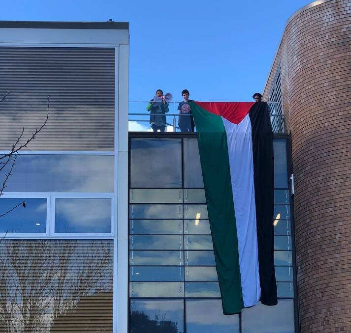 A six-metre Palestine flag is unfurled by protestors at the University of New England in Armidale on Sunday, May 26. Picture supplied. 