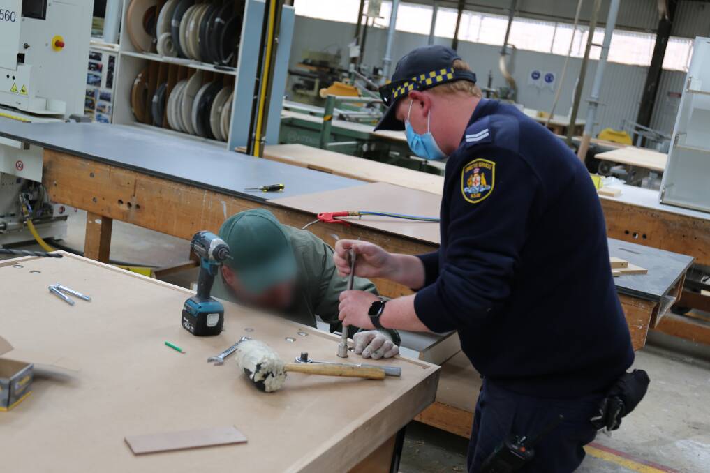 Officers and inmates at Goulburn Correctional Centre work side-by-side to produce desks and workbenches for schools and are expanding into bed bases. 