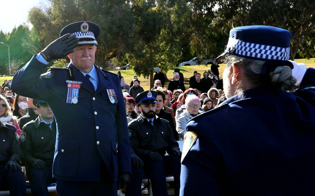 Chief Inspector Peter Forbutt signs off a 40-year career with a final salute to Police Commissioner Karen Webb on June 23. 