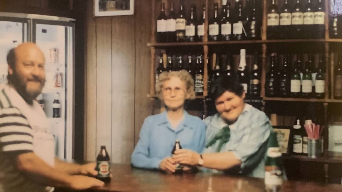 Ron Miller about to drink the first beer sold in the Gundaroo Inn (Wine Bar) for almost a century while owner Beat Crowe and daughter Kaye watch on. Picture supplied