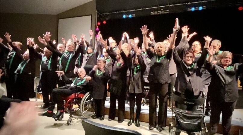 Members of Greenacres' This is Me Choir, and their support people, raise their arms during their performance of 'I still call Australia home' at Figtree Anglican Church on Tuesday, June 25. Picture: Angela Thompson 