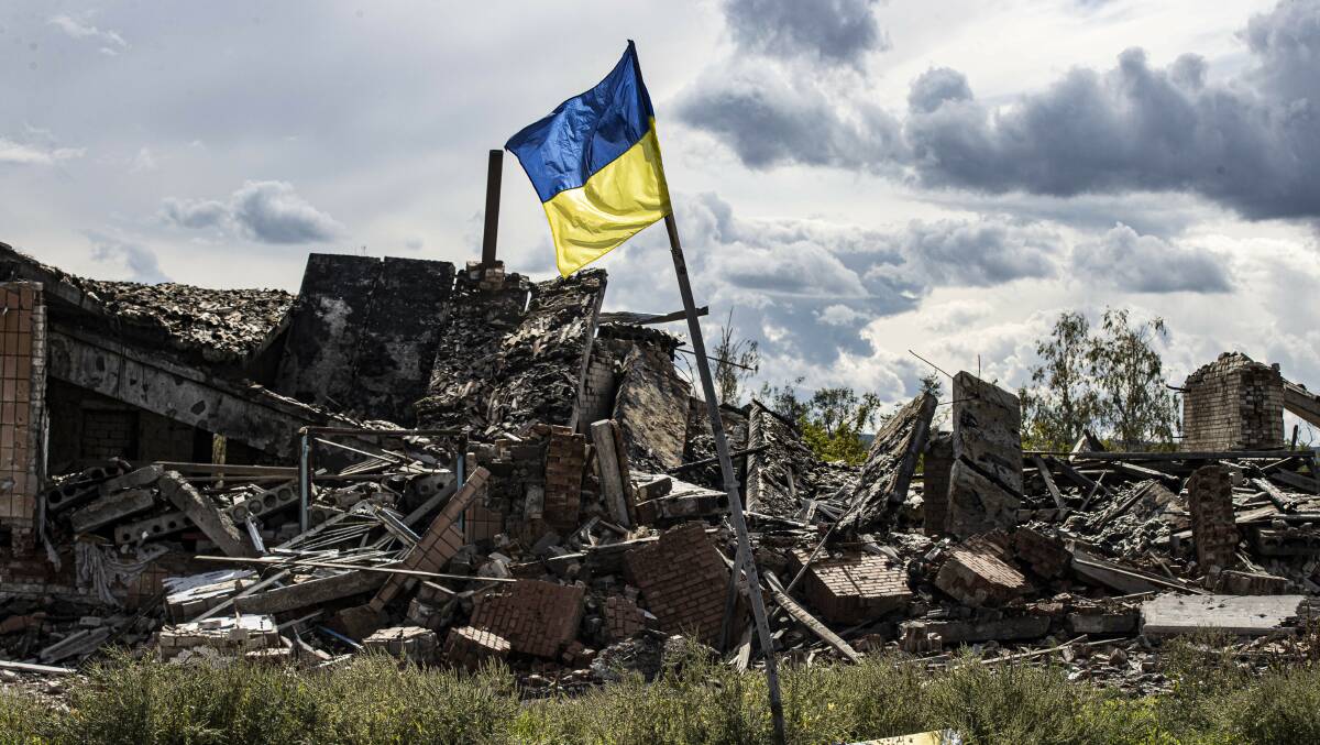 Ukrainian flag waves in a residential area heavily damaged in the village of Dolyna in Donetsk Oblast, Ukraine after the withdrawal of Russian troops. Picture Shutterstock