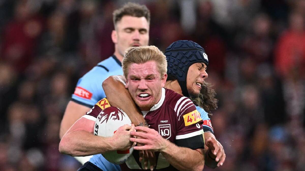 Tom Dearden, who had a big game for the Maroons, is tackled by Jarome Luai. (Dave Hunt/AAP PHOTOS)