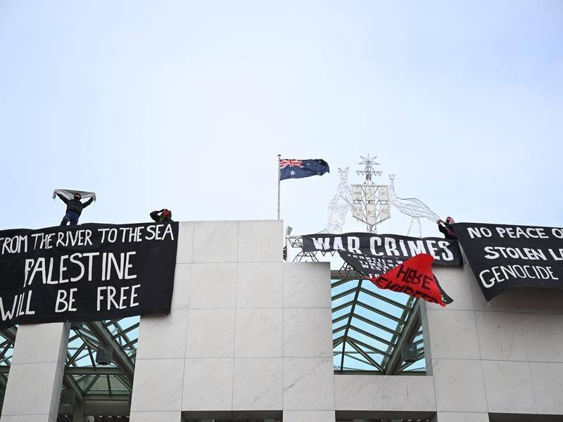 Pro-Palestine protesters have hung banners from the top of Parliament House in Canberra. (Lukas Coch/AAP PHOTOS)