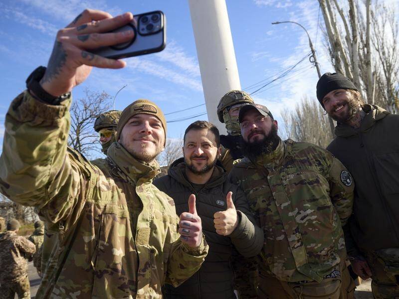 Ukrainian President Volodymyr Zelenskiy poses with servicemen as he visits Kherson. (EPA PHOTO)
