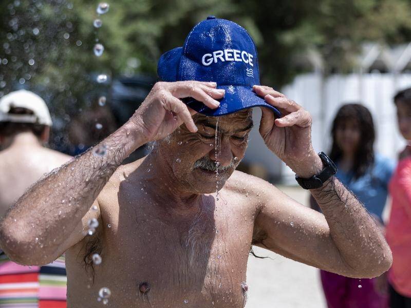 A man cools himself in Athens as a heatwave continues across Greece. (AP PHOTO)
