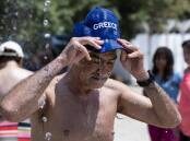 A man cools himself in Athens as a heatwave continues across Greece. (AP PHOTO)