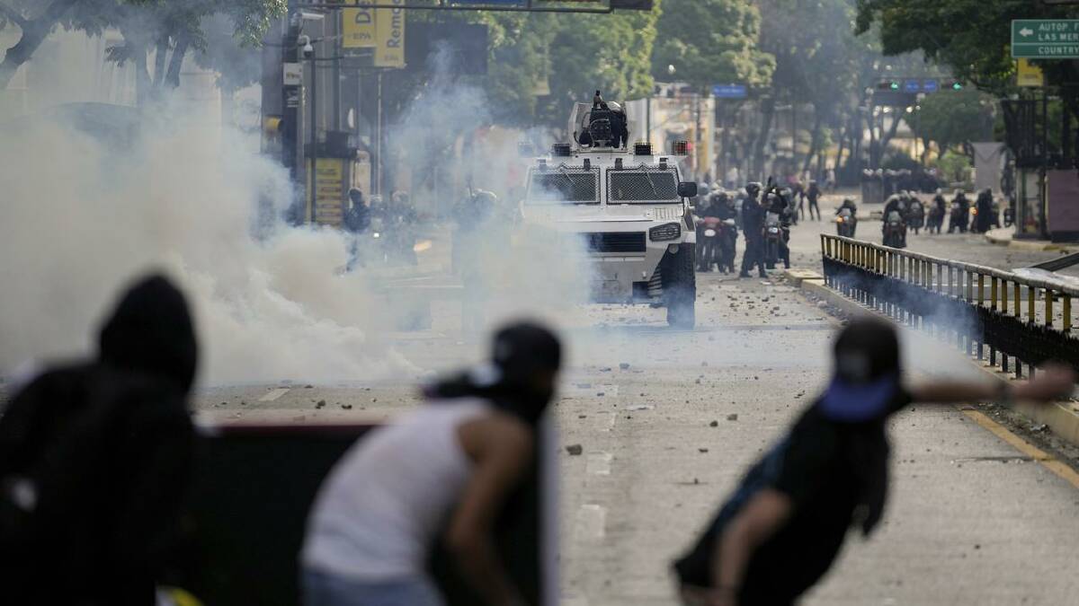 Riot police used tear gas in clashes with protesters in Caracas. (AP PHOTO)