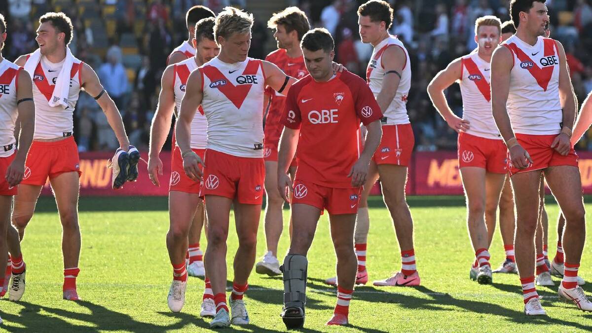 Isaac Heeney consoles an injured Tom Papley after the Swans' loss in Brisbane. (Darren England/AAP PHOTOS)