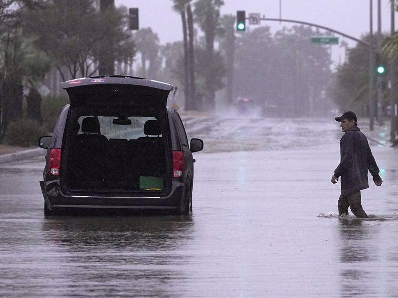 A motorist in a flooded street in Palm Desert, California amid Tropical Storm Hilary. (AP)