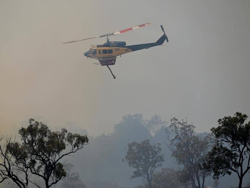 Water-bombing helicopters have been deployed to help fight bushfires raging across Queensland. (Darren England/AAP PHOTOS)