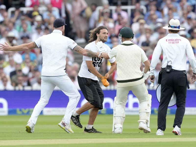 Ben Stokes (l) and David Warner prevent a demonstrator from making his way to the pitch at Lord's. (AP PHOTO)